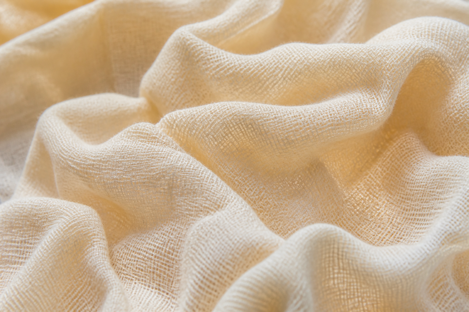 Macro close-up of crinkled cotton gauze showing the loose open weave