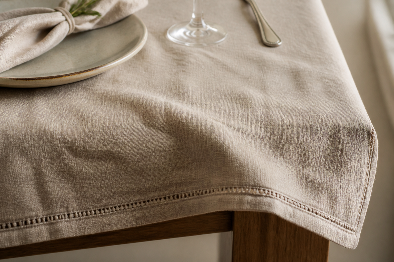 Close-up of a beige washed linen tablecloth with fine hemstitch detail