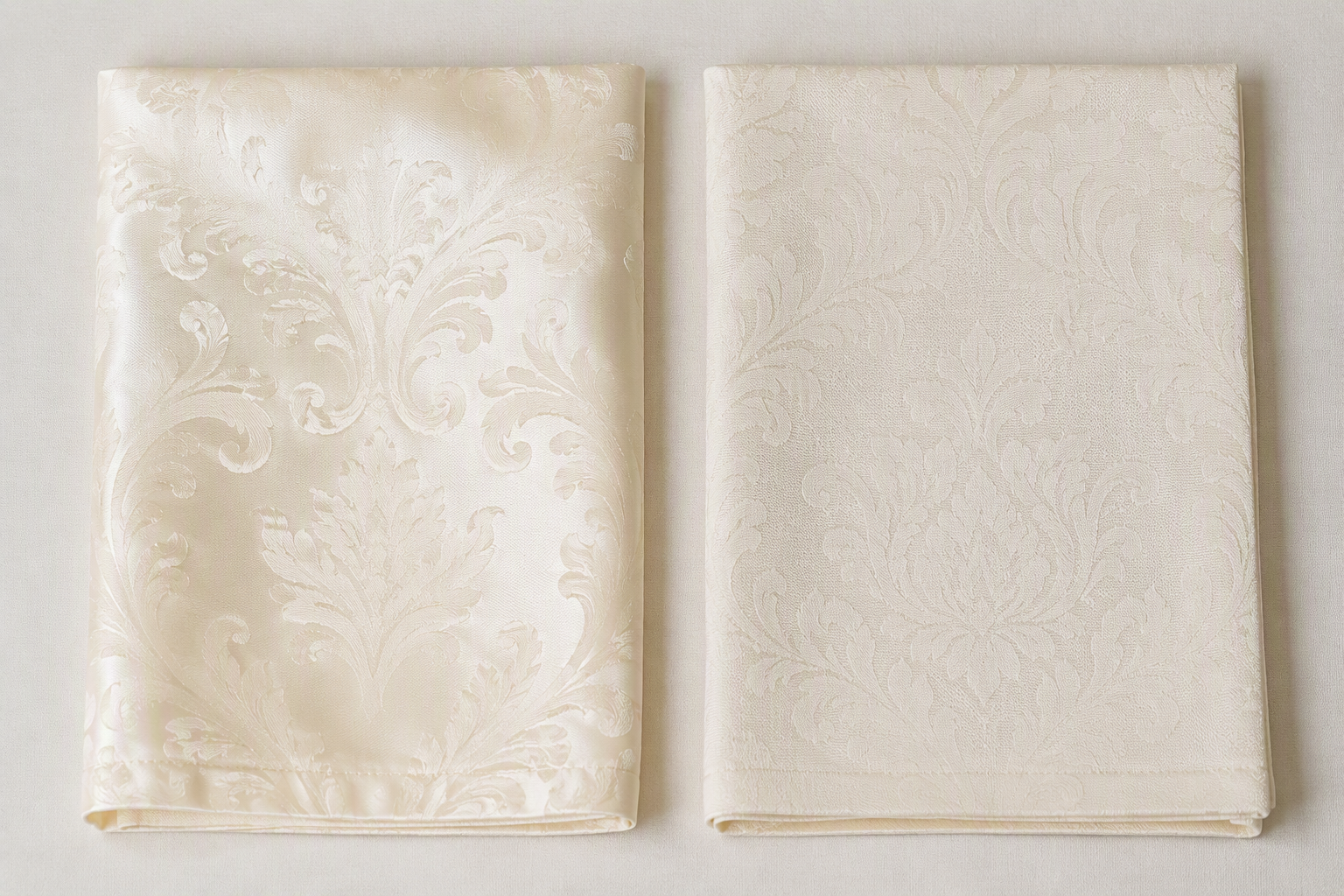 Two ivory damask napkins side by side showing the front satin-finish pattern and the reverse matte pattern