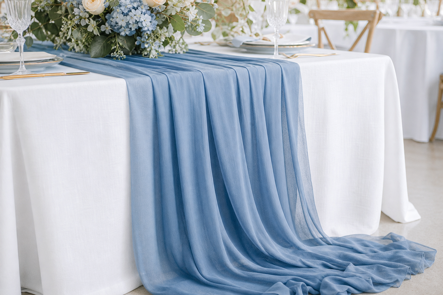 Sheer chiffon table runner in dusty blue cascading down a banquet table with gathered folds