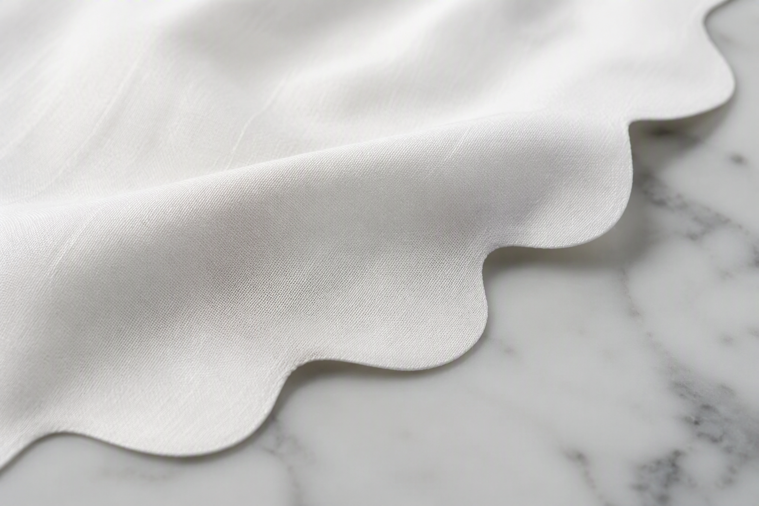 White cloth napkin with a clean laser-cut curved edge and no visible stitching