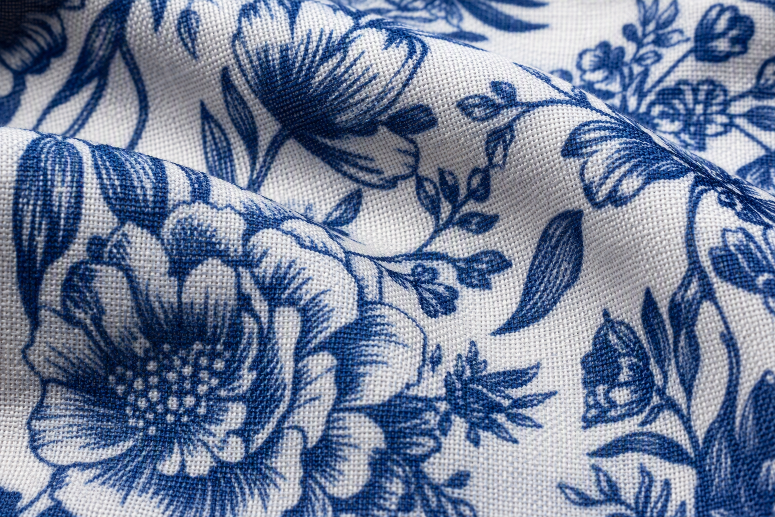 Macro close-up of a cloth napkin with a fine floral print in navy on white showing weave texture