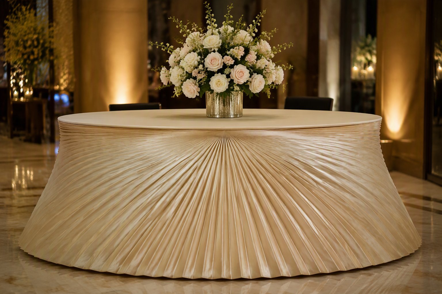 Round reception desk with a champagne sunray pleated table skirt fanning from the centre