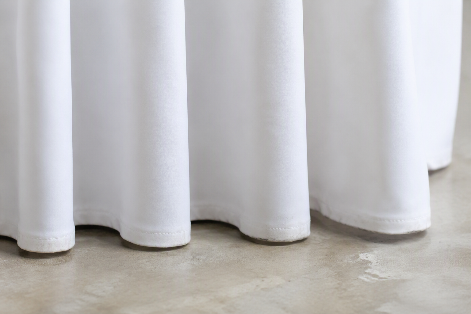 Close-up of the bottom hem of a pleated table skirt near the floor