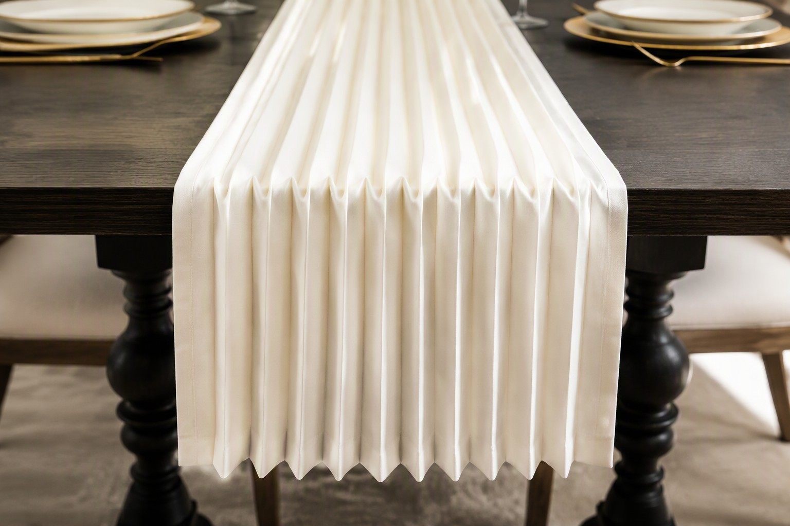 A pleated ivory table runner with sharp even pleats on a dark table