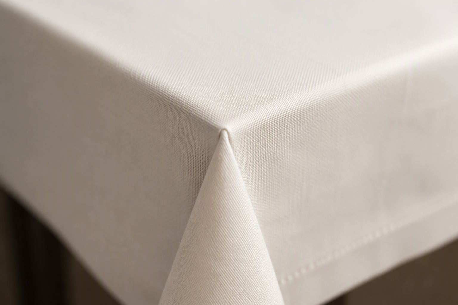 A tablecloth corner folded at a precise 45-degree mitered angle