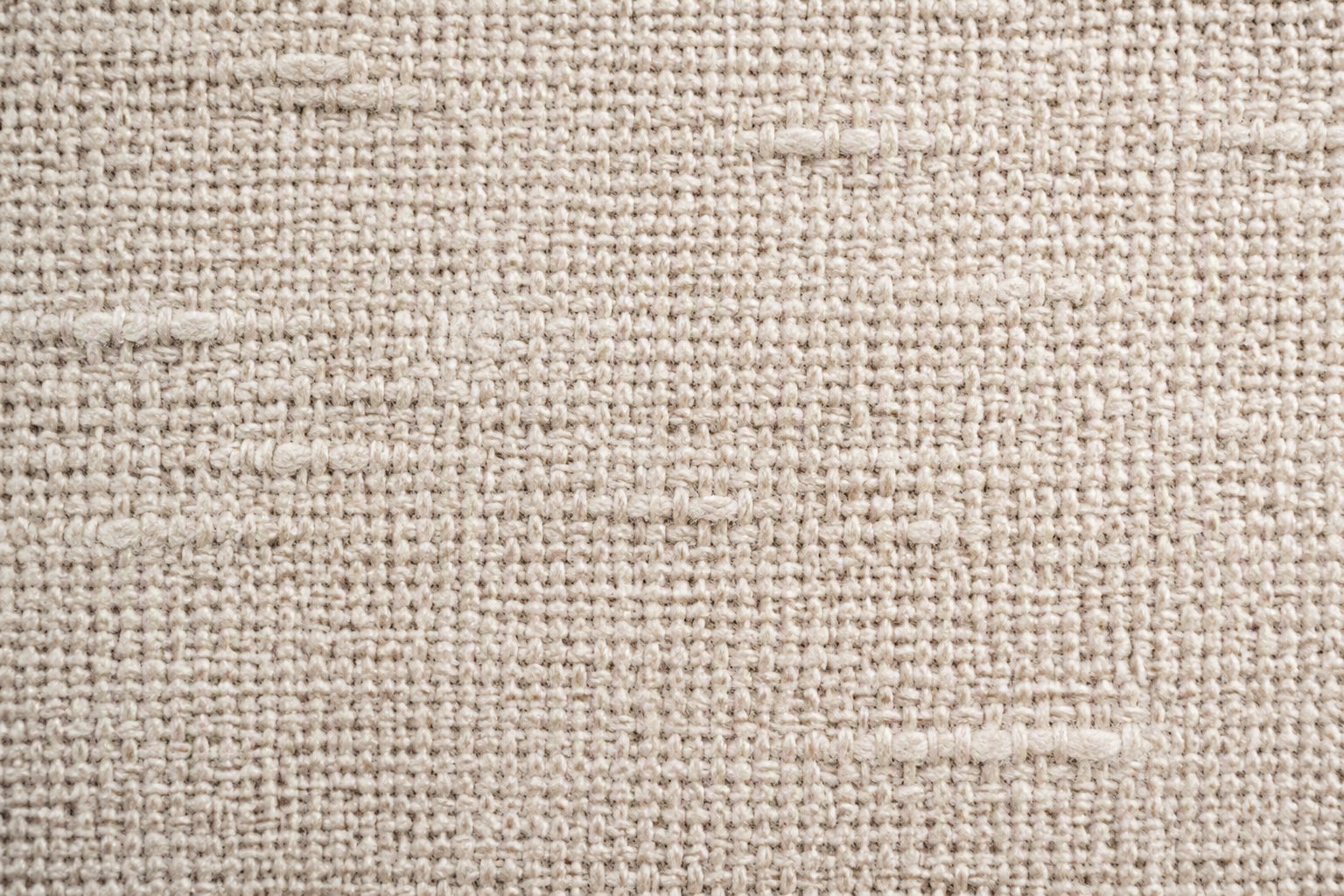 A macro close-up of cotton-linen blend weave with irregular natural slub yarns running through a tight plain weave