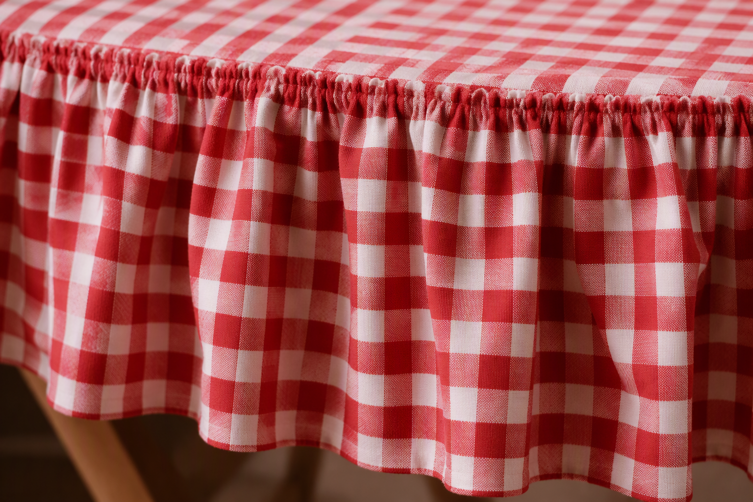 The gathered ruffle border edge of a red-and-white gingham tablecloth