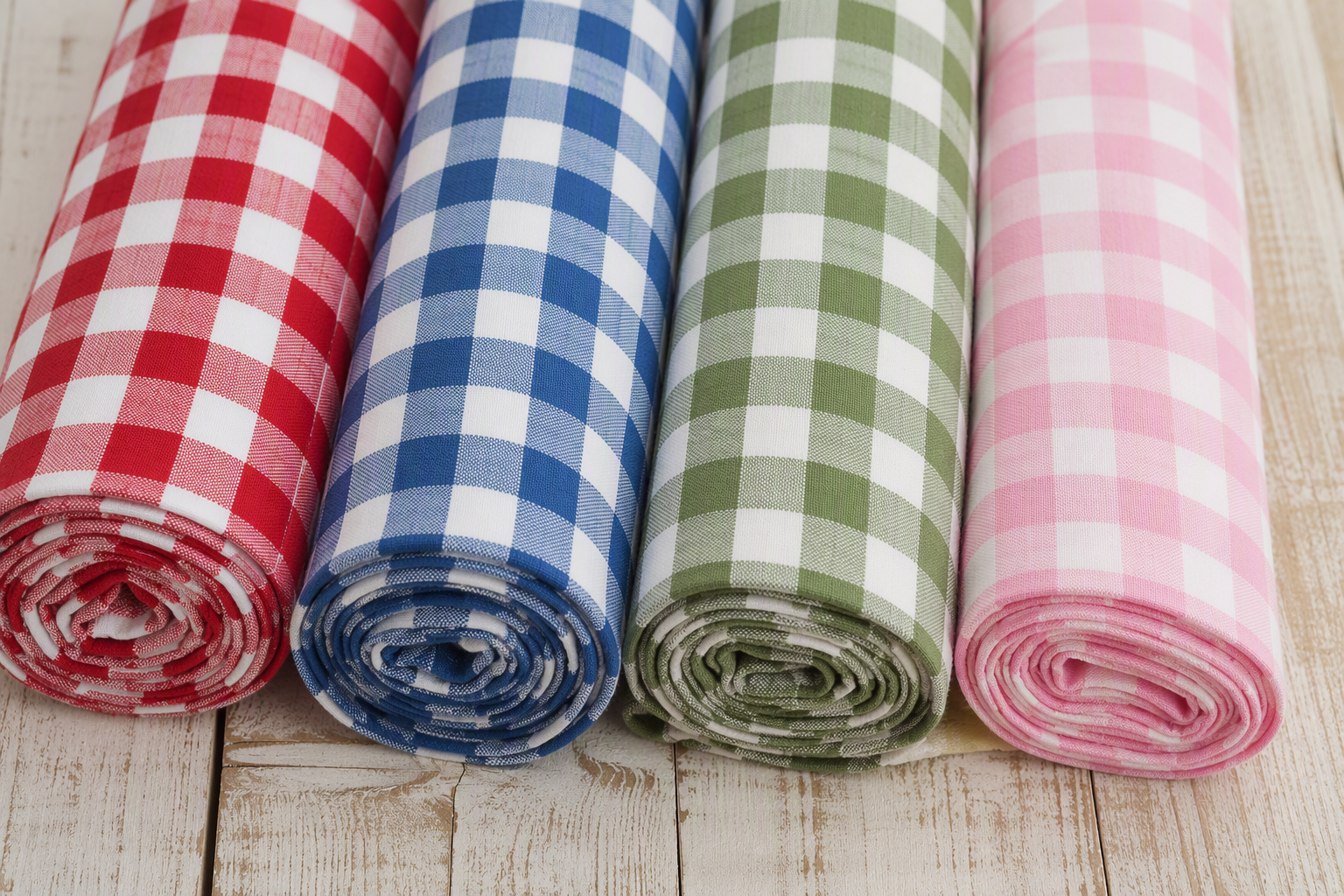 Gingham tablecloths rolled in red, blue, green and pastel colourways
