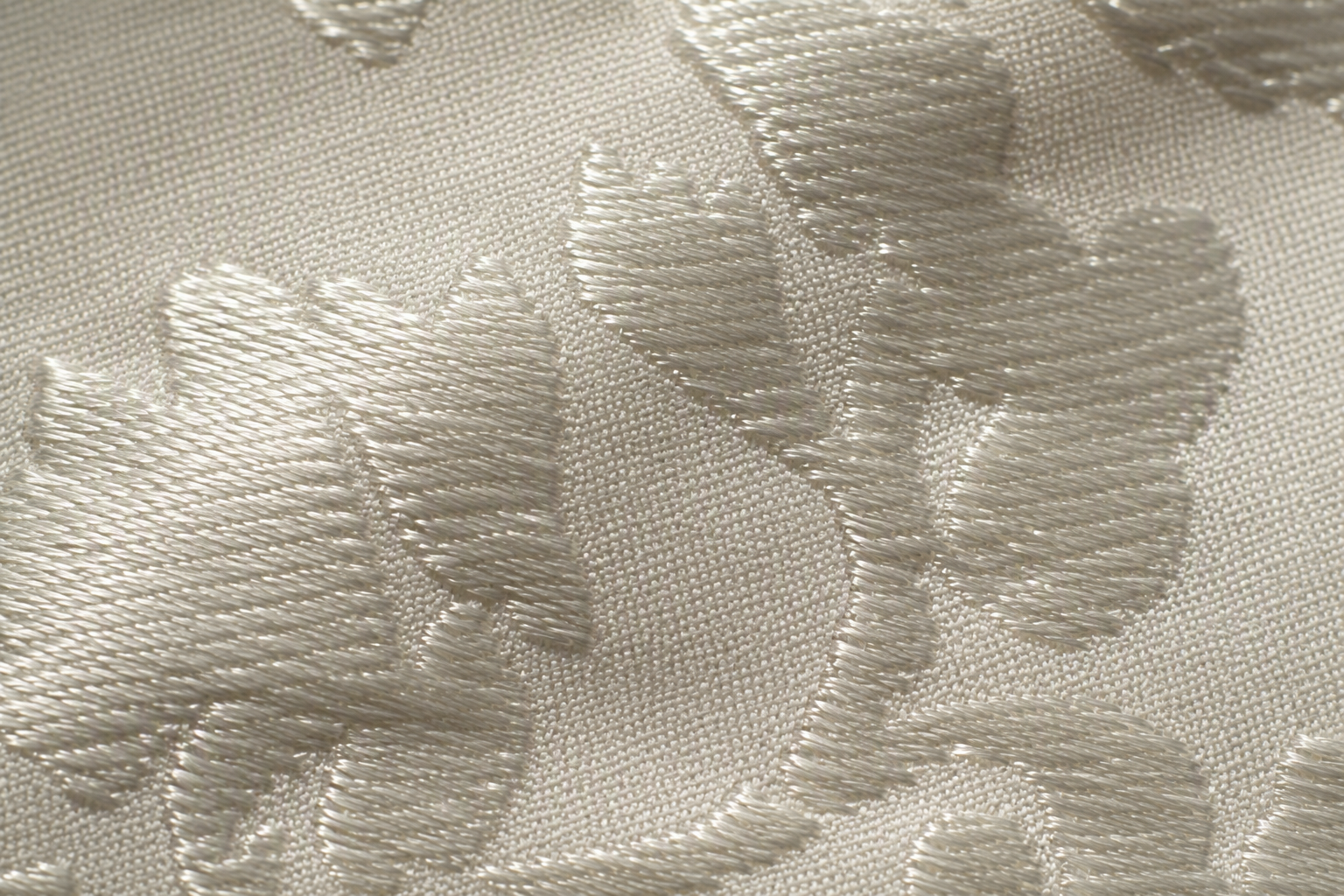 Macro of ivory damask fabric showing the self-coloured woven floral motif