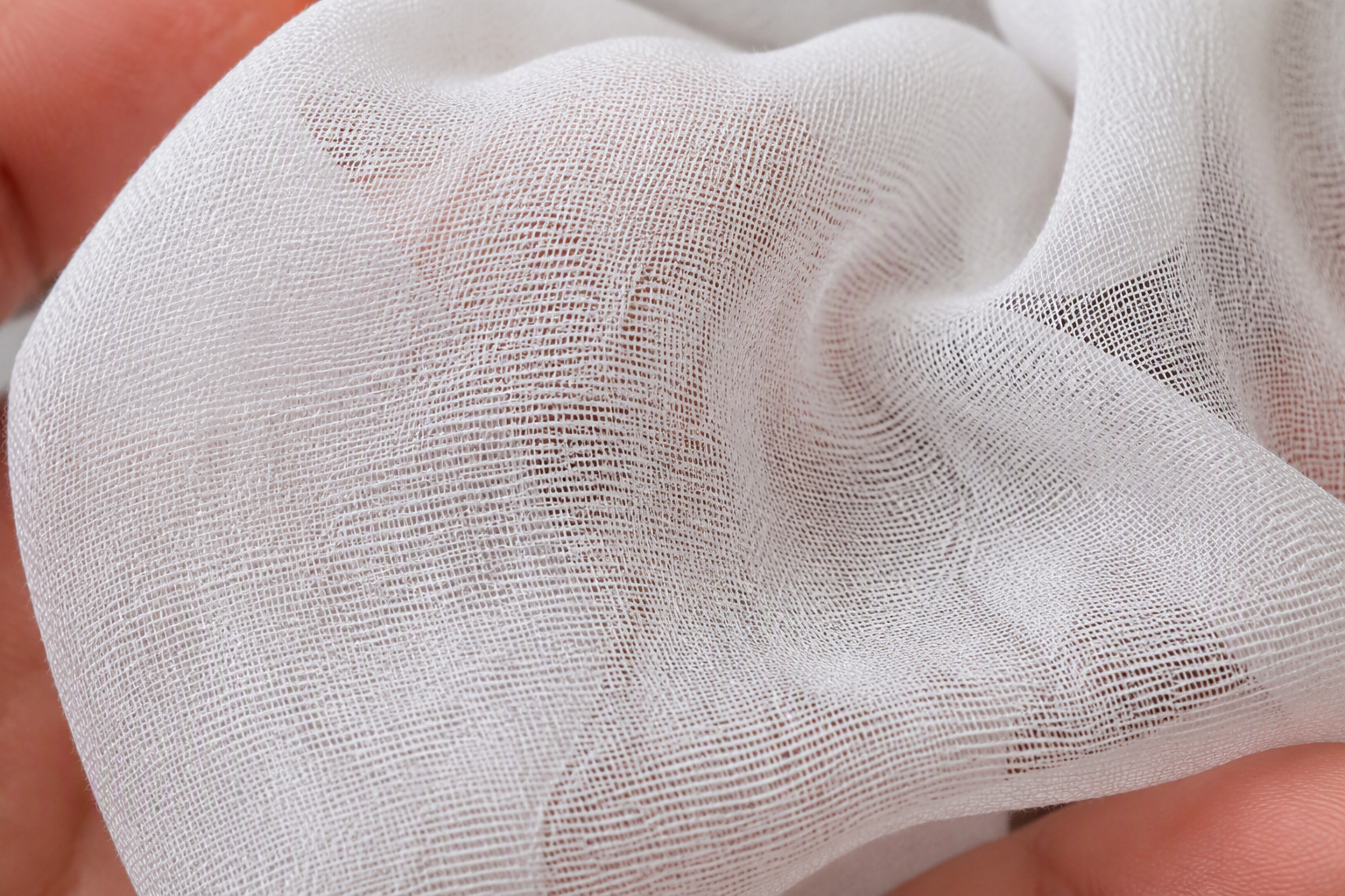 Macro of white chiffon fabric showing the fine yarn and loose plain weave